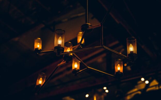 Un lustre industriel design dans un intérieur contemporain, mettant en valeur des matériaux bruts et des lignes épurées.